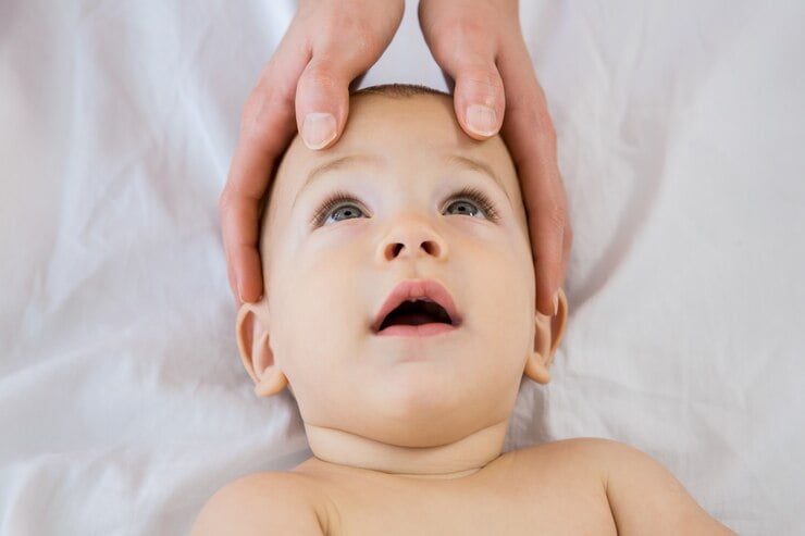 hands mother touching head her baby boy